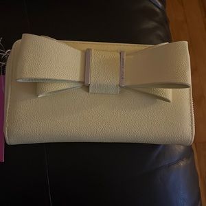 Betsey Johnson yellow wristlet has a strap on the side of wristlet